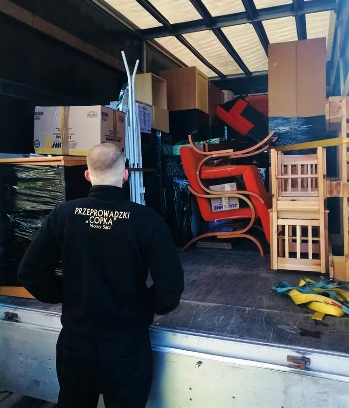 Pracownik COPKA Transport przy załadunku mebli do samochodu